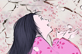 a girl looking in awe up at falling cherry blossoms