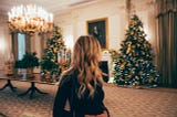 Woman surveying a room of amazing Christmas decorations she slaved over all month