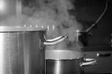 Steaming pots in a black and white.