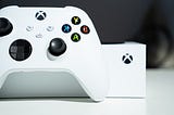 A white Series controller in front of an Xbox Series S