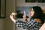 girl taking photo of pizza from her iphone