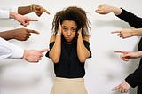 People pointing a finger at a scared woman.