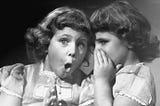 One little girl sharing a secret with her friend.