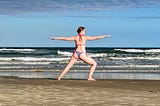 Foto da Ana praticando yoga à beira mar