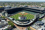 Aerial image of Wrigley Field and its surrounding rooftops. Chicago Cubs sign is visible. Photo by Sea Cow. Creative commons license.