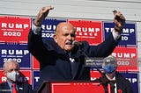 Rudy Giuliani, evangelizes the cult of Trump at a news conference in the parking lot of a landscaping company on 11/7/20.
