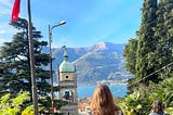 A woman’s brunette hair shines in the sun looking out at Lake Como, Italy.