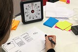 Solo designer sketching with a time timer and post-it notes
