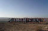 Image of a group of Jewish teenagers holding hands triumphantly at the top of Masada in Israel