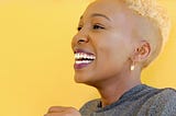 Black woman with short blond hair laughing