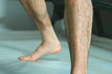 A man’s bare legs, shown from roughly the knees down.