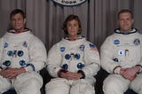 Three astronauts sitting in as row