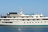 A large white yacht with four streamlined decks and many portholes.
