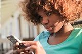 Photo of a woman staring at her smart phone.