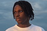 Man in white t-shirt staring into the distance