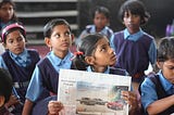 Children reading news paper.