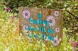 Hand painted plywood sign with donuts and the phrase, “a better world is possible”