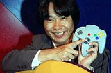 Miyamoto showing the analog stick of the N-64 controller.