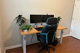 Very clean wooden computer desk with chair and two monitors