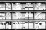 Black and White image of an unoccupied modern office space at night.