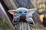 Baby Yoda holding a cup