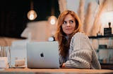 Image taken from unsplash — Image of a woman with a laptop in a cafe