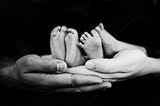 Image of person holding babies’ feet