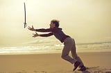 Man dropping his sword on the beach like an idiot