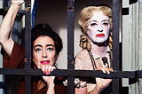 An anguished looking Joan Crawford and a heavily made up Bette Davis peering through black bars.