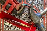 A wrench, a hammer and a fancy pen lying on an expensive notebook