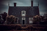 creepy looking house under storm clouds