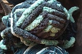 3 bundles of yarn; 1 is navy, the other 2 are varying shades of light to dark blue.