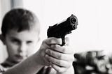 Young boy pointing gun at unseen target