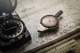 Black and grey compass on top of map photo