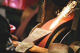 Stock photo of a man forging an axe.