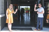 Two people waving at the entrance to a walkway. Greatest Hits (So Far) by Jim Latham