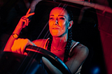 A woman driving a car, listening to music.