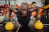 A black man in his fifty doing a workout in a fitness studio