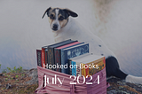 A dog sitting behind a stack of books