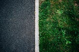 Photo of asphalt separated from grass with a white dividing line, by Will Francis on Unsplash.