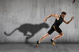 Young man running with shadow of cheetah in the background