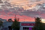 pink clouds over downtown building roofs