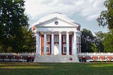 University of Virginia Rotunda with green lawn and blue sky beyond.