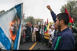 An Israeli flag burns at a protest in Iran