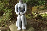 blue porcelain statue of a kappa with cucumber offerings near the Kappabuchi pool in Tono, Iwate Prefecture, Japan