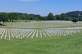 Veterans cemetery decorated with American flags in front of each headstone.