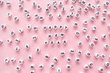 Letters scattered on a pink background