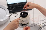 A silly picture of multiple hands messing with an electronic setup indicating chaos. Relates to article as testing is all about trying every chaotic scenario to break something.