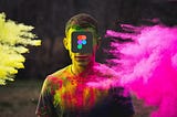 Imagem com um homem ao centro com a logo do Figma cobrindo seu rosto e fumaças coloridas nas laterais.