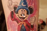 Micky Mouse pointing upwards while wearing wizard hat from the film Fantasia.